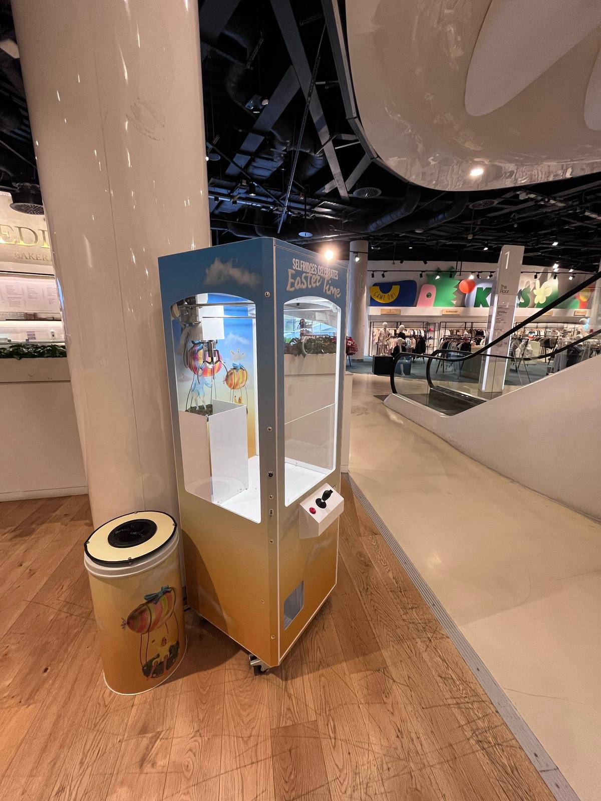 Fully branded prize claw machine in a shopping centre.